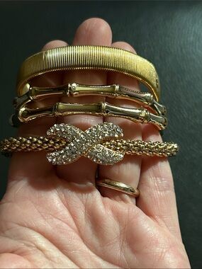 Set of 4 Gold Tone Bracelets.
